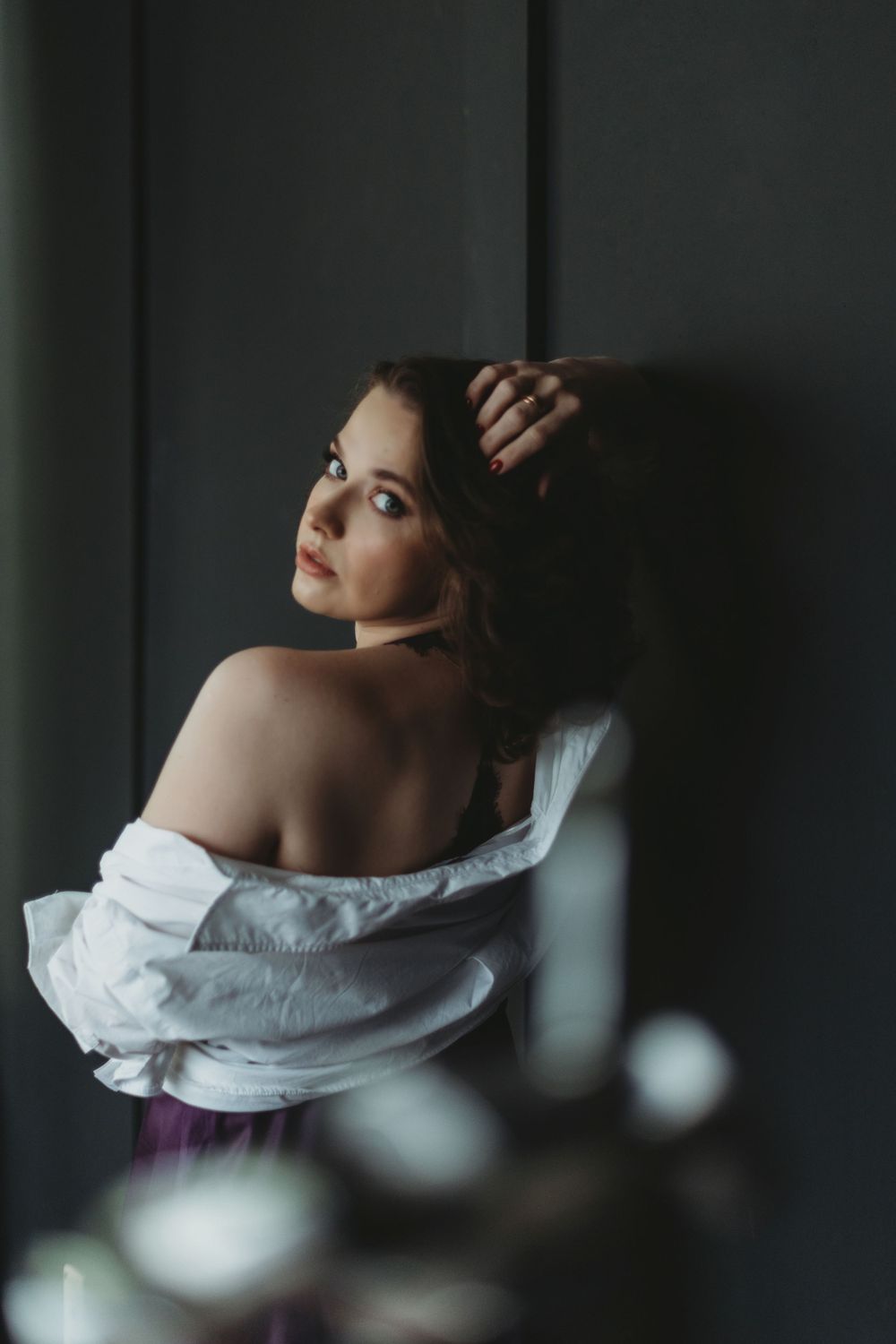 Artistic portrait with dramatic side lighting and white off-shoulder garment. Bellevue studio, WA