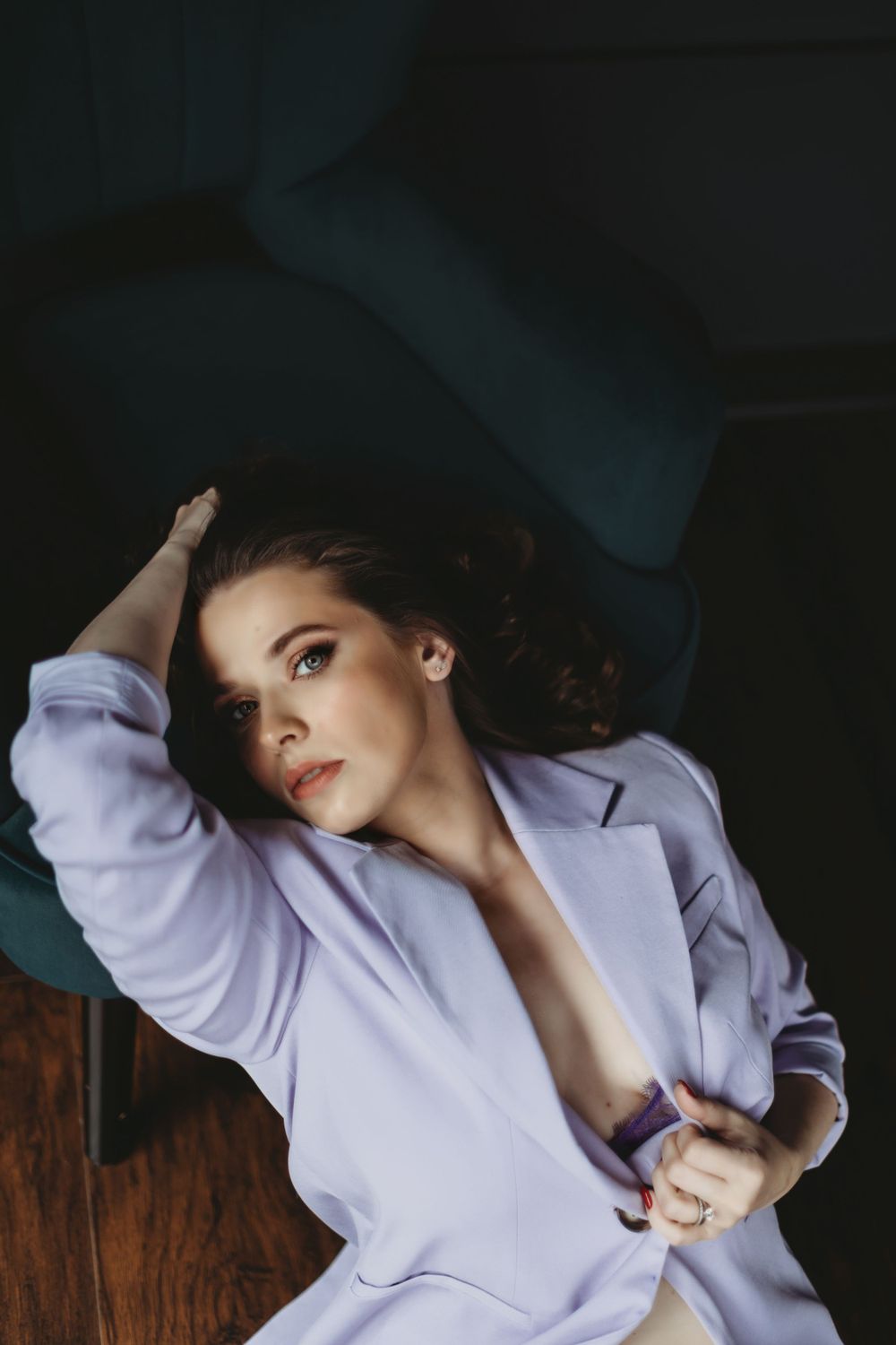 Fashion portrait with person in lavender blazer lounging on wooden surface. Bellevue studio, WA