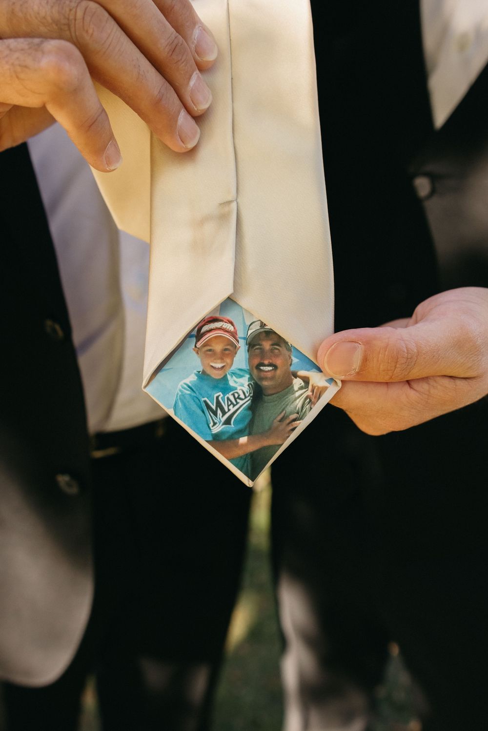 Hands holding a small photograph tucked inside a white envelope.
