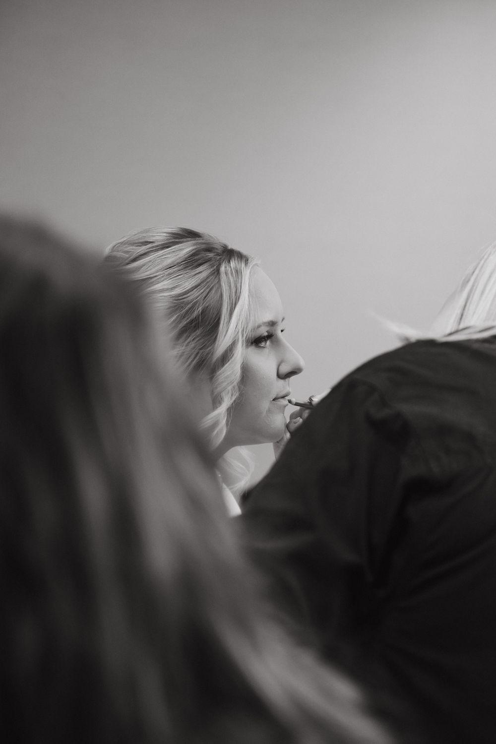 Black and white profile view showing a candid moment during preparation.