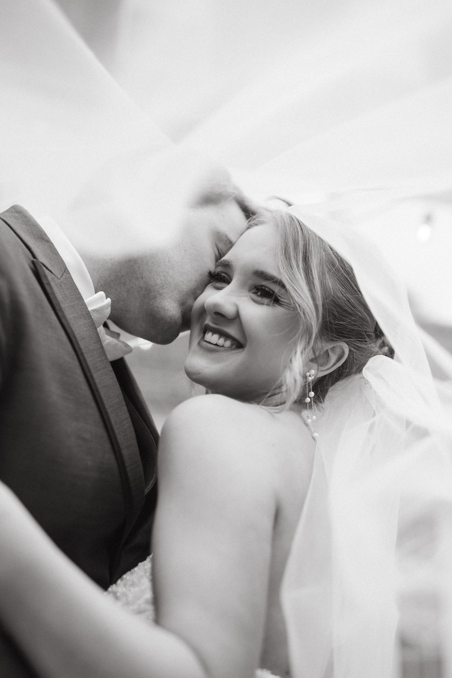 An intimate black and white wedding portrait capturing a tender moment.