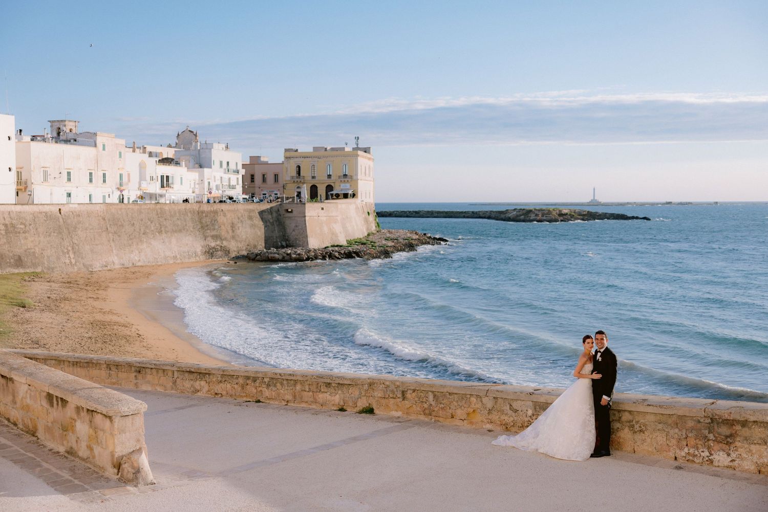 Coastal wedding scene overlooking a sandy beach with historic stone fortress walls and Mediterranean Sea in the background in Gallipoli.