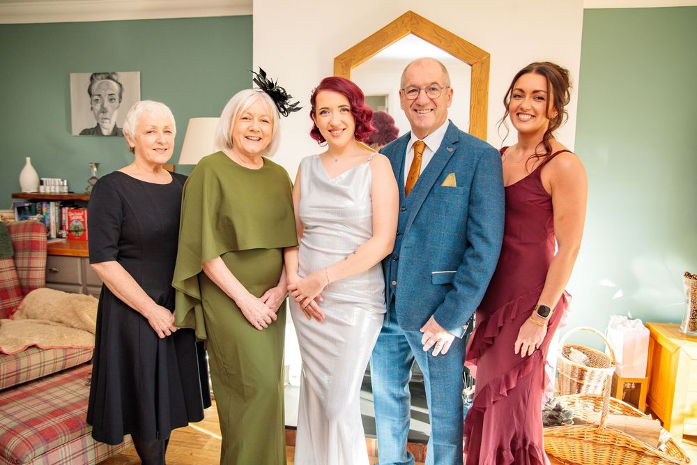 A group photo of wedding party members in coordinated formal attire.