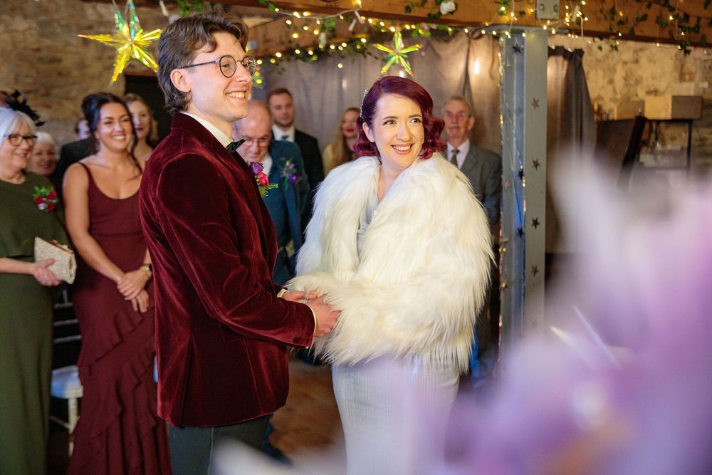 Wedding celebration in rustic venue with string lights and decorative touches.