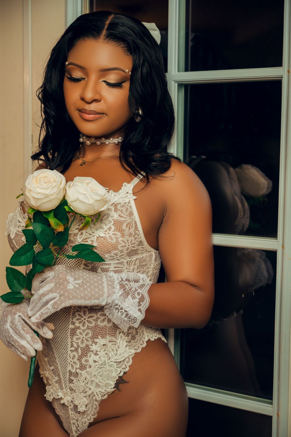Elegant boudoir portrait with white roses and delicate lace details.