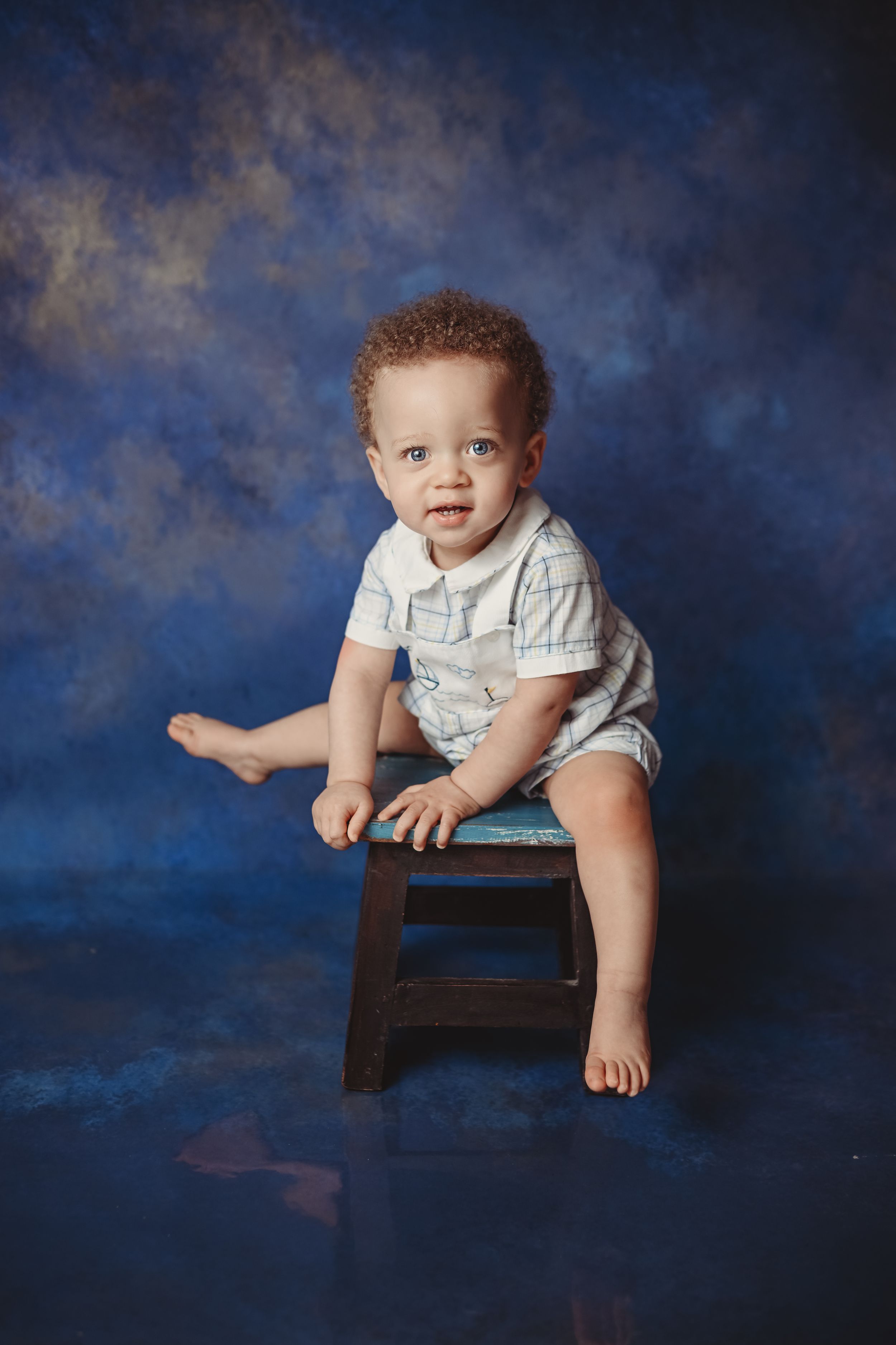 Professional studio portrait setup with dark blue backdrop.