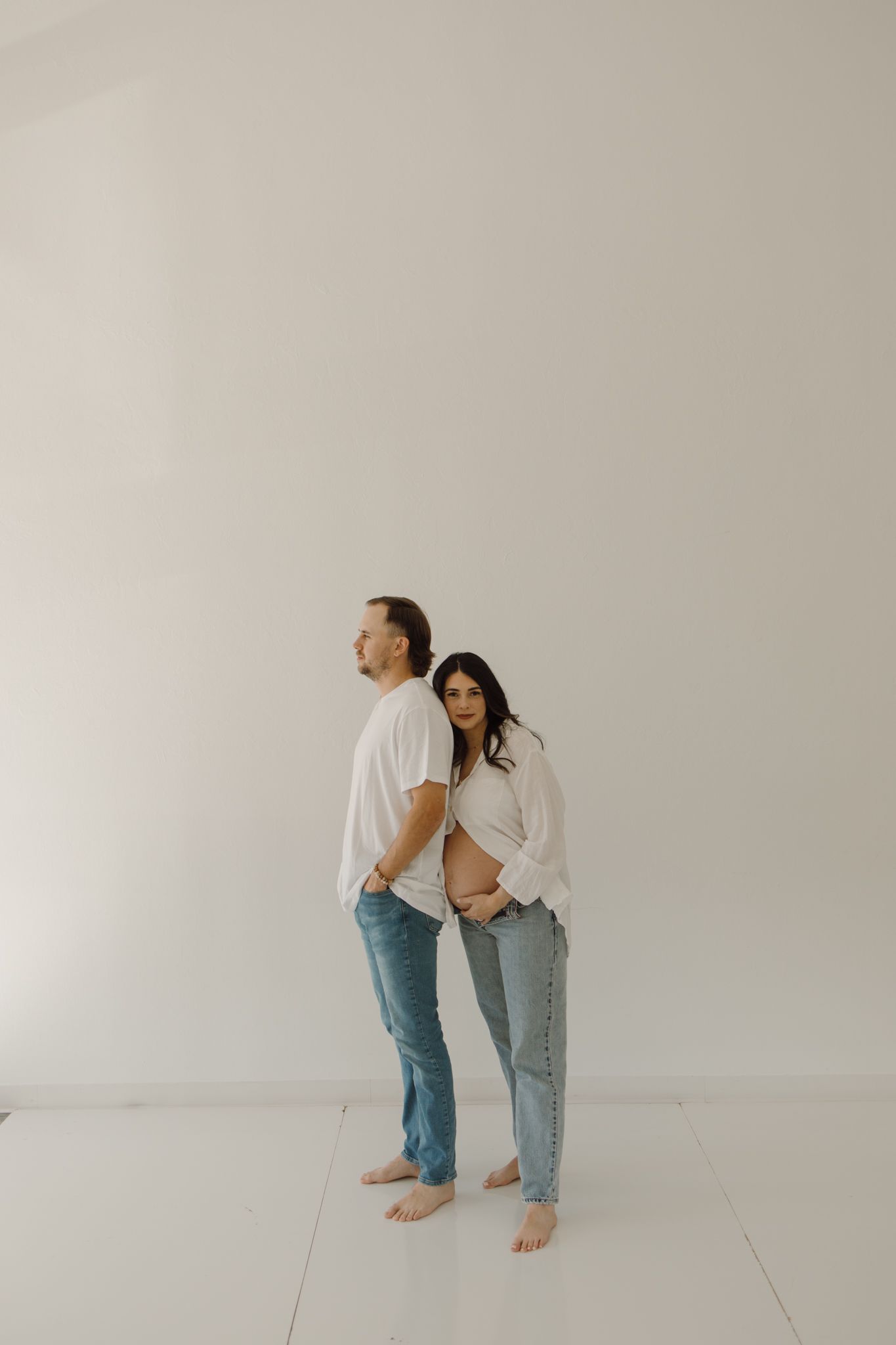 Minimalist portrait against white background showing casual style and intimate connection.