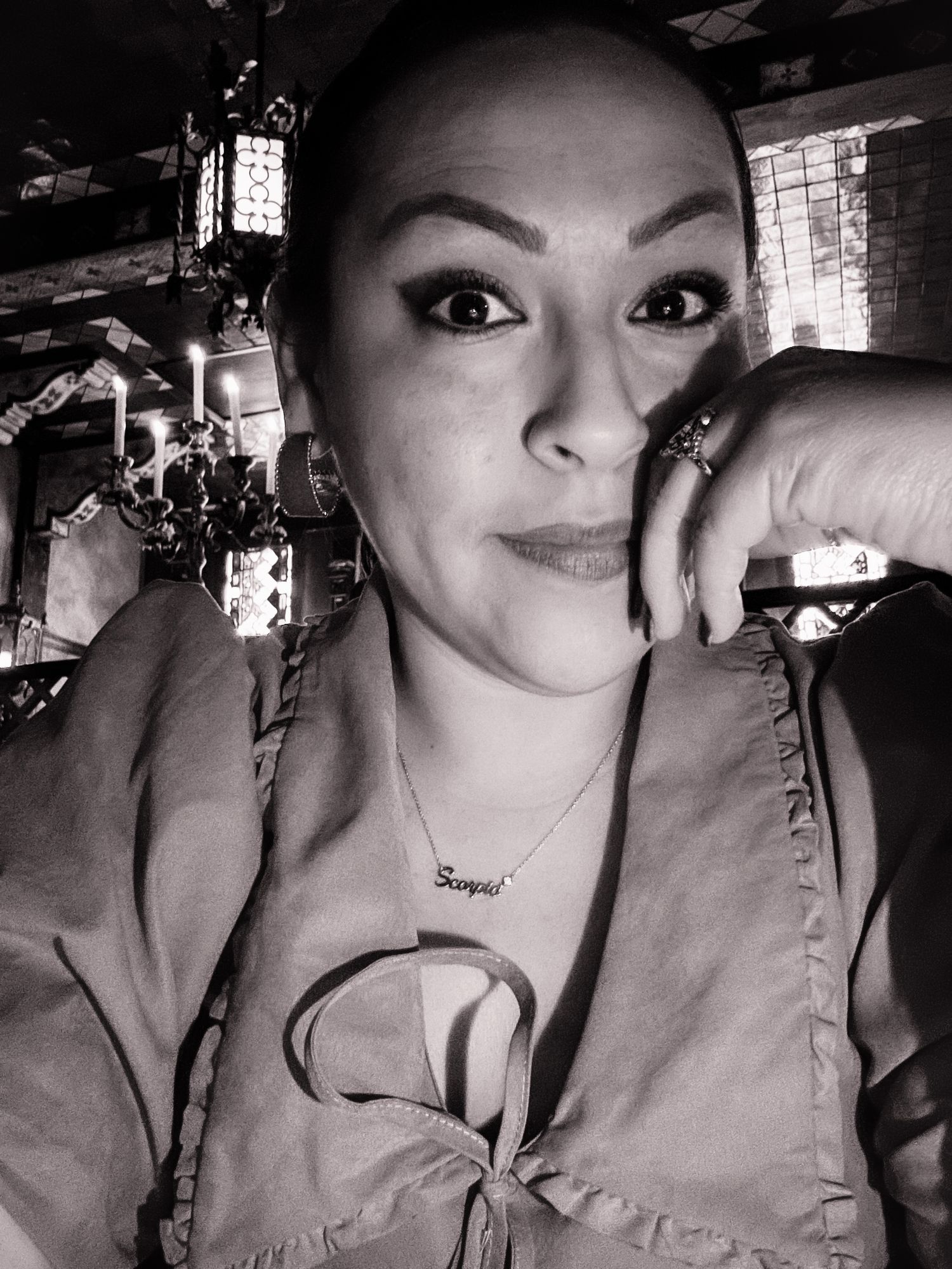 A dramatic black and white portrait in moody lighting with decorative lanterns in background.