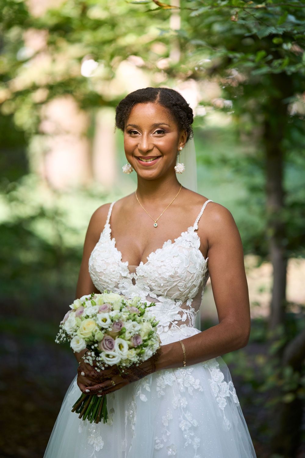 Une mariée souriante avec un bouquet de fleurs.