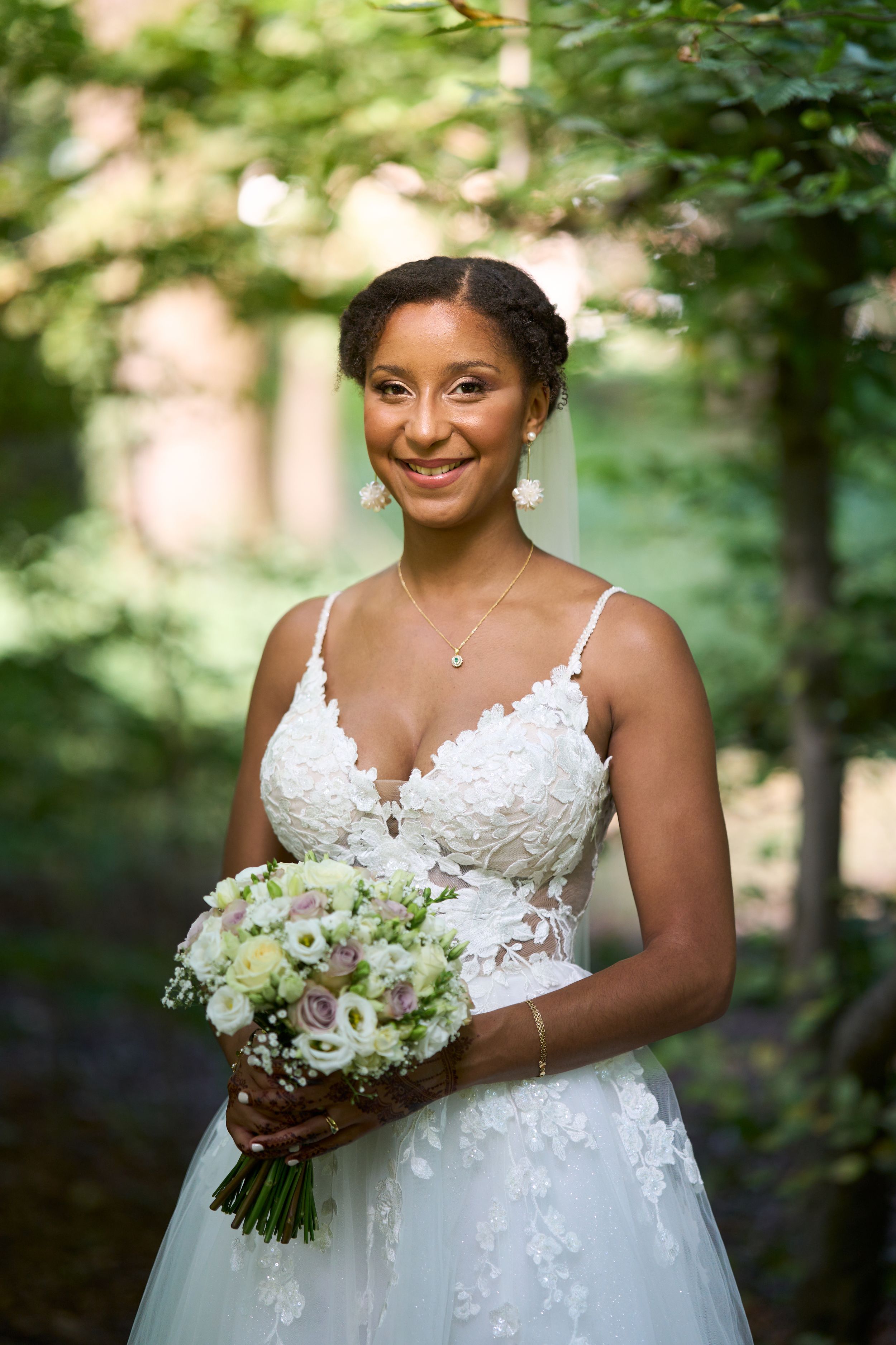 Une mariée souriante avec un bouquet de fleurs.