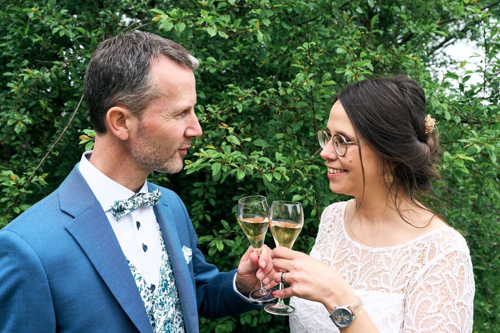 Un couple de mariés échangent devant une coupe de champagne.