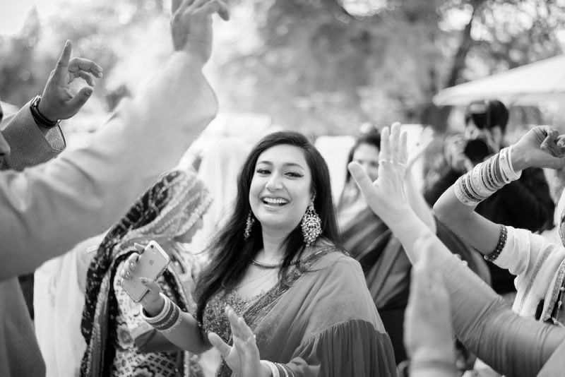 Celebratory dancing and festivities at an Indian wedding with guests in traditional attire.