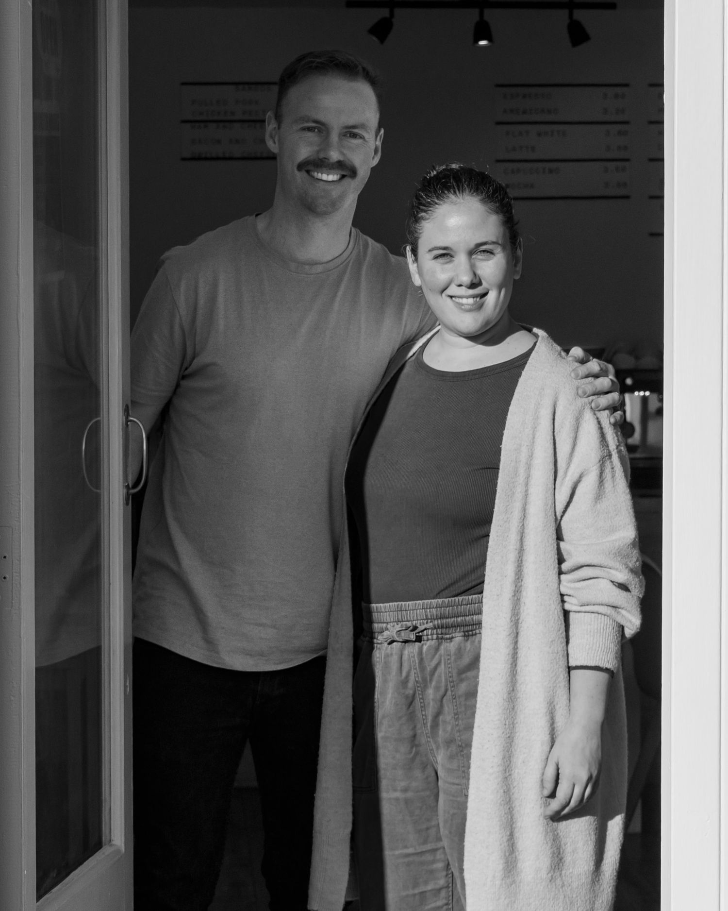 Interior black and white photo of cafe staff in casual attire.