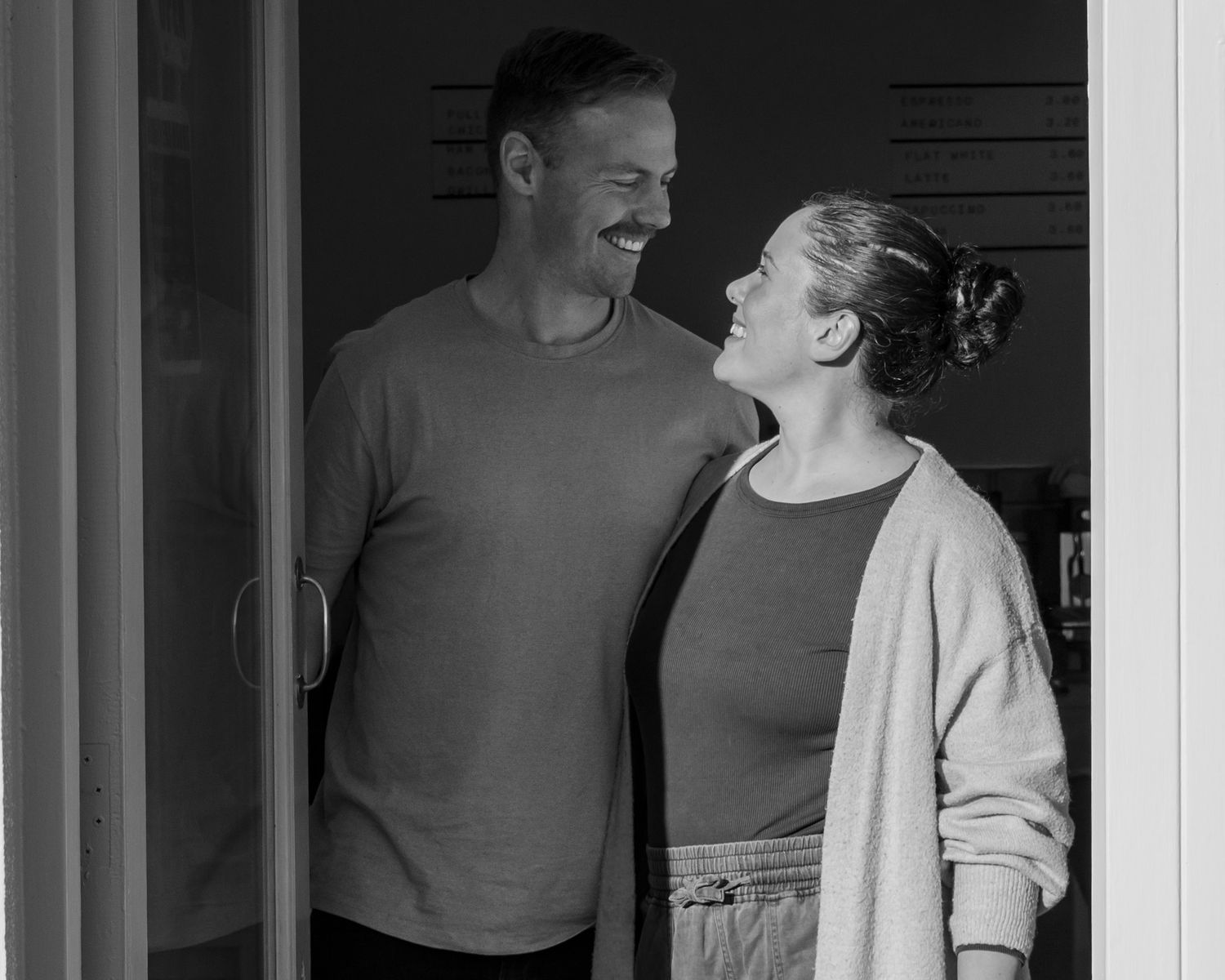 Candid moment between cafe workers in black and white photography.