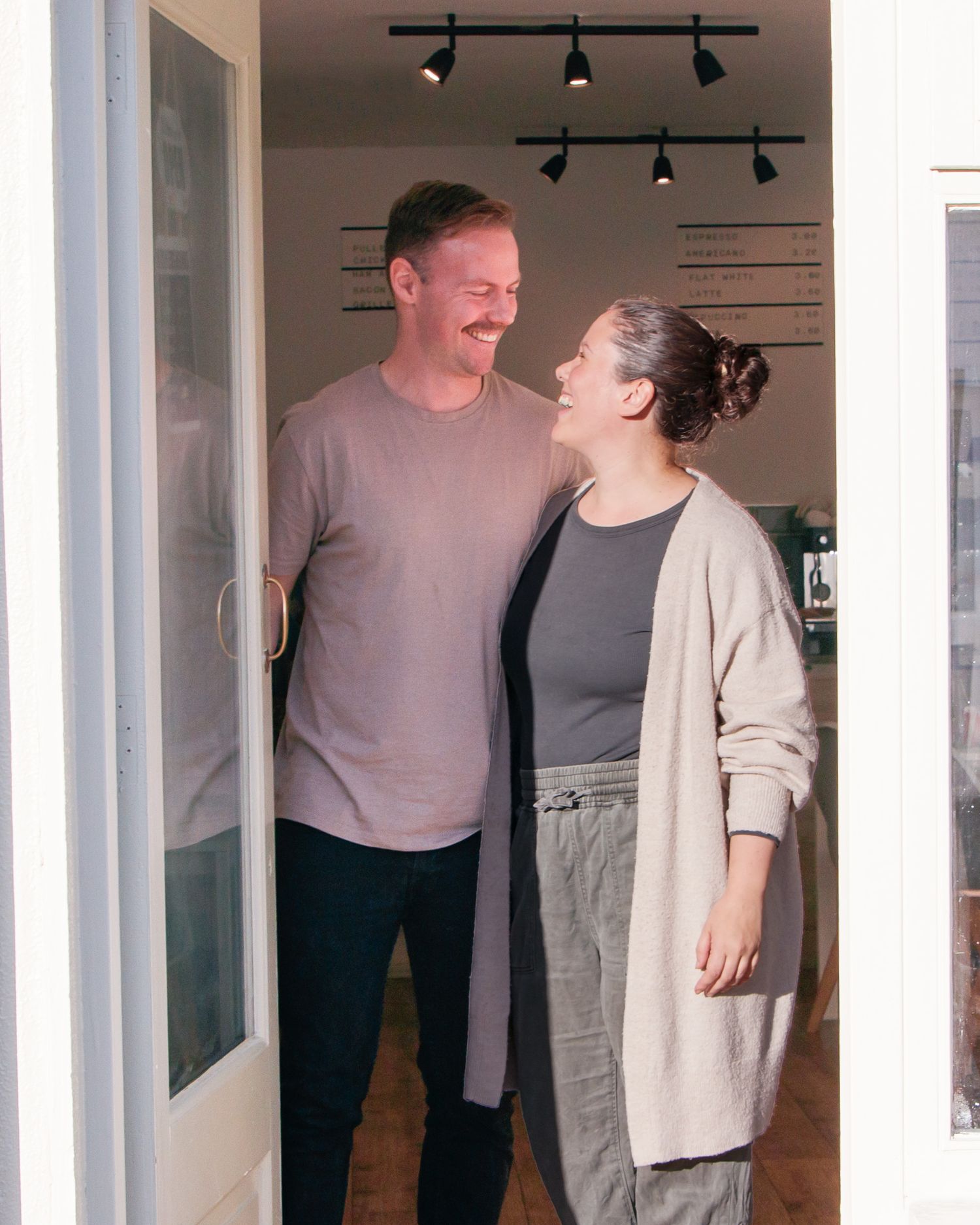 Interior shot of cafe workers sharing a lighthearted moment.