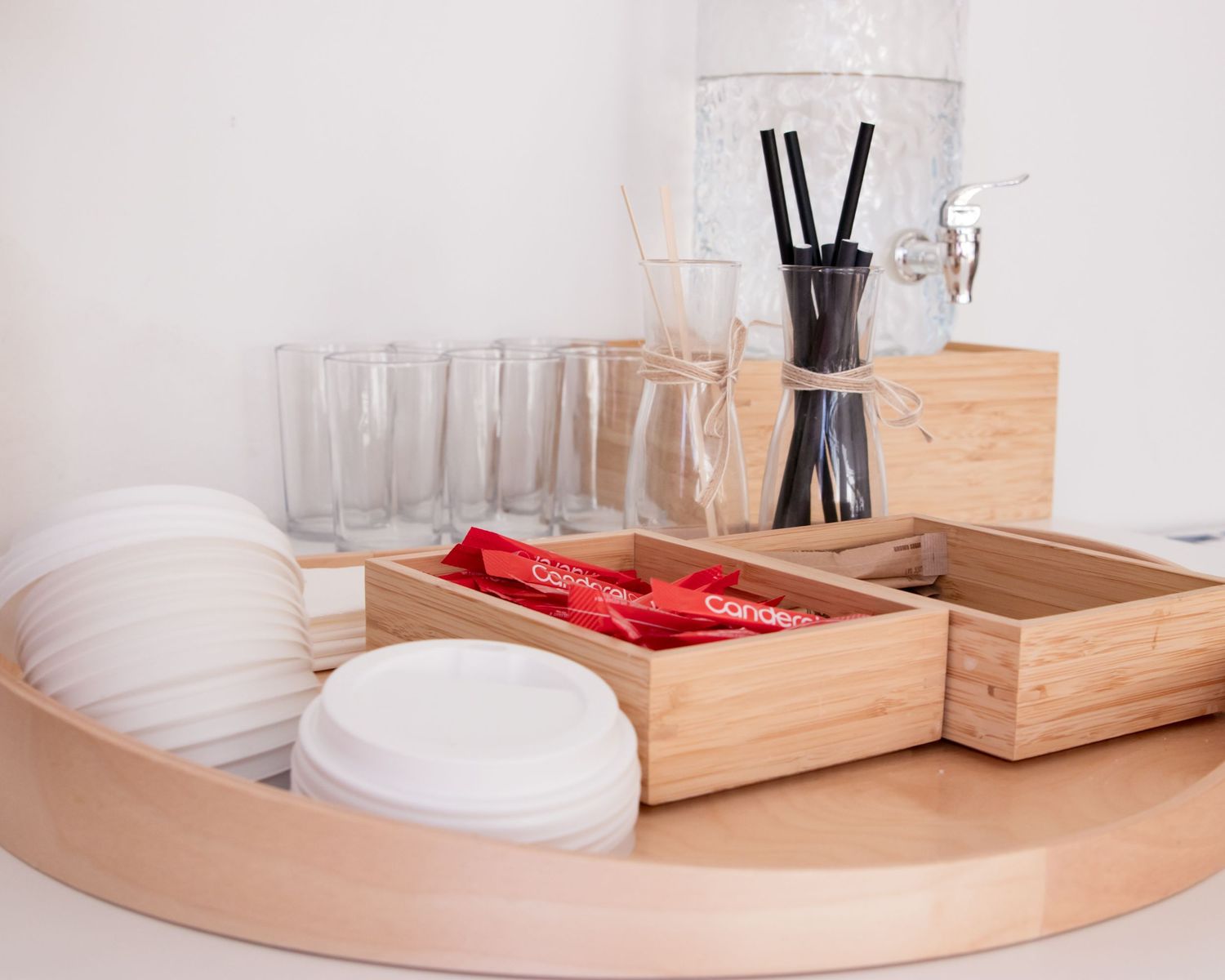 Wooden serving trays and coffee accessories arranged neatly on a white counter.