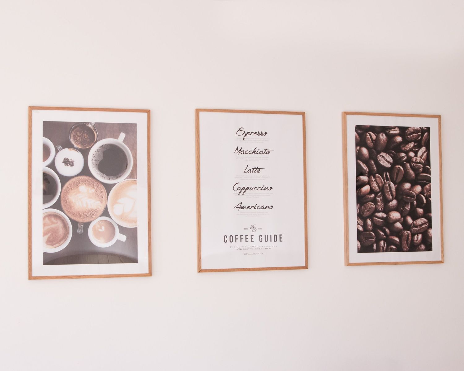 Modern cafe wall decor featuring coffee-themed artwork and prints arranged in a minimalist gallery style.