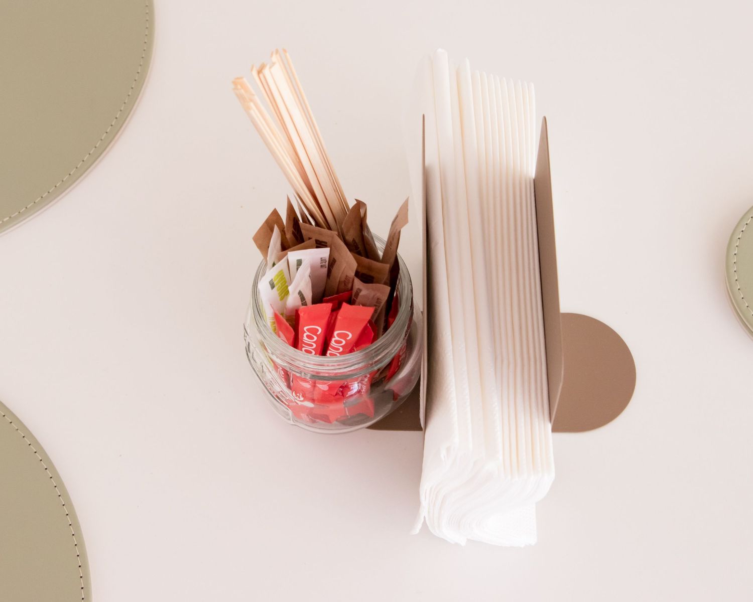 Close-up of wooden utensil holders and coffee accessories on a light surface.