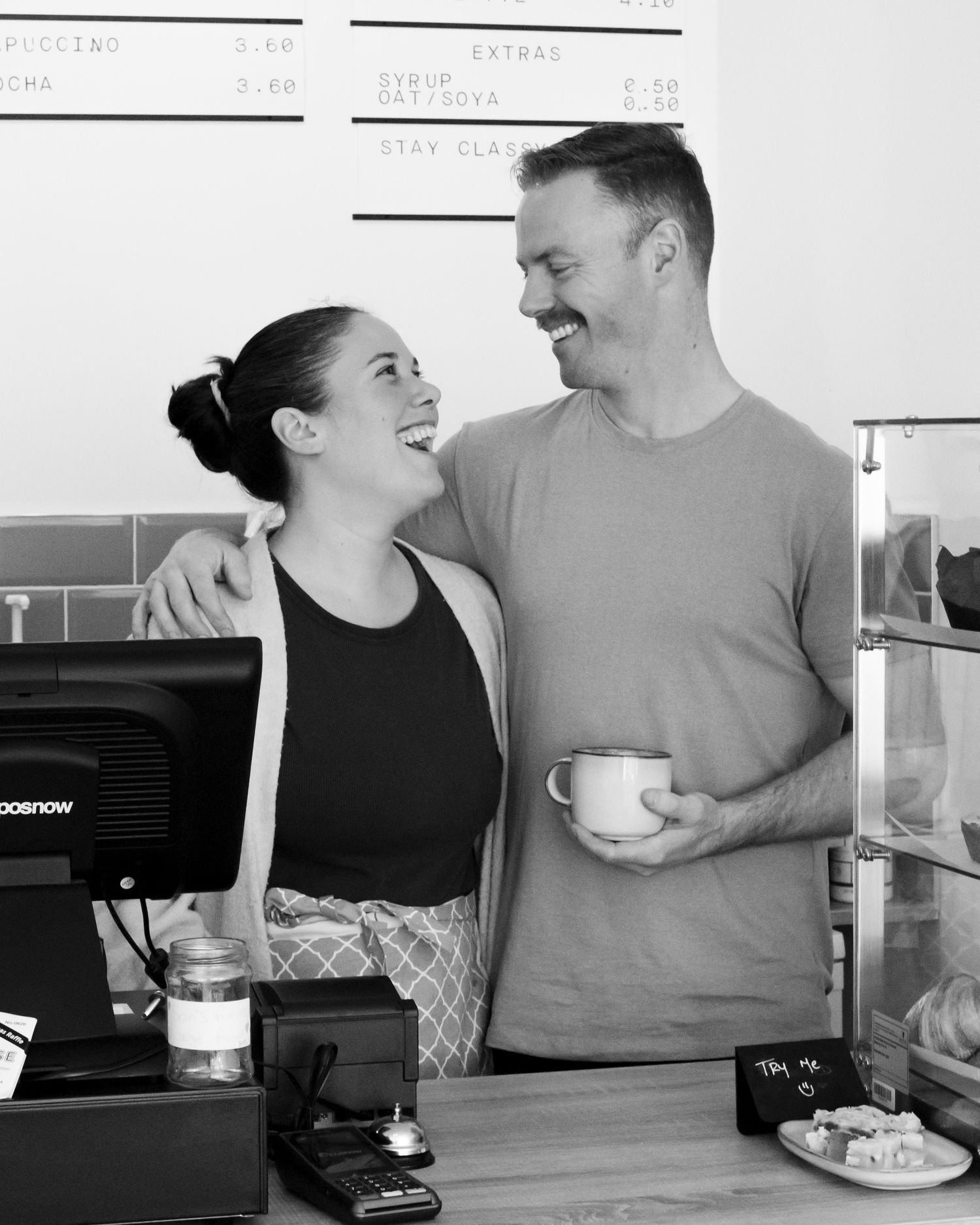 Black and white image of a coffee shop counter interaction.