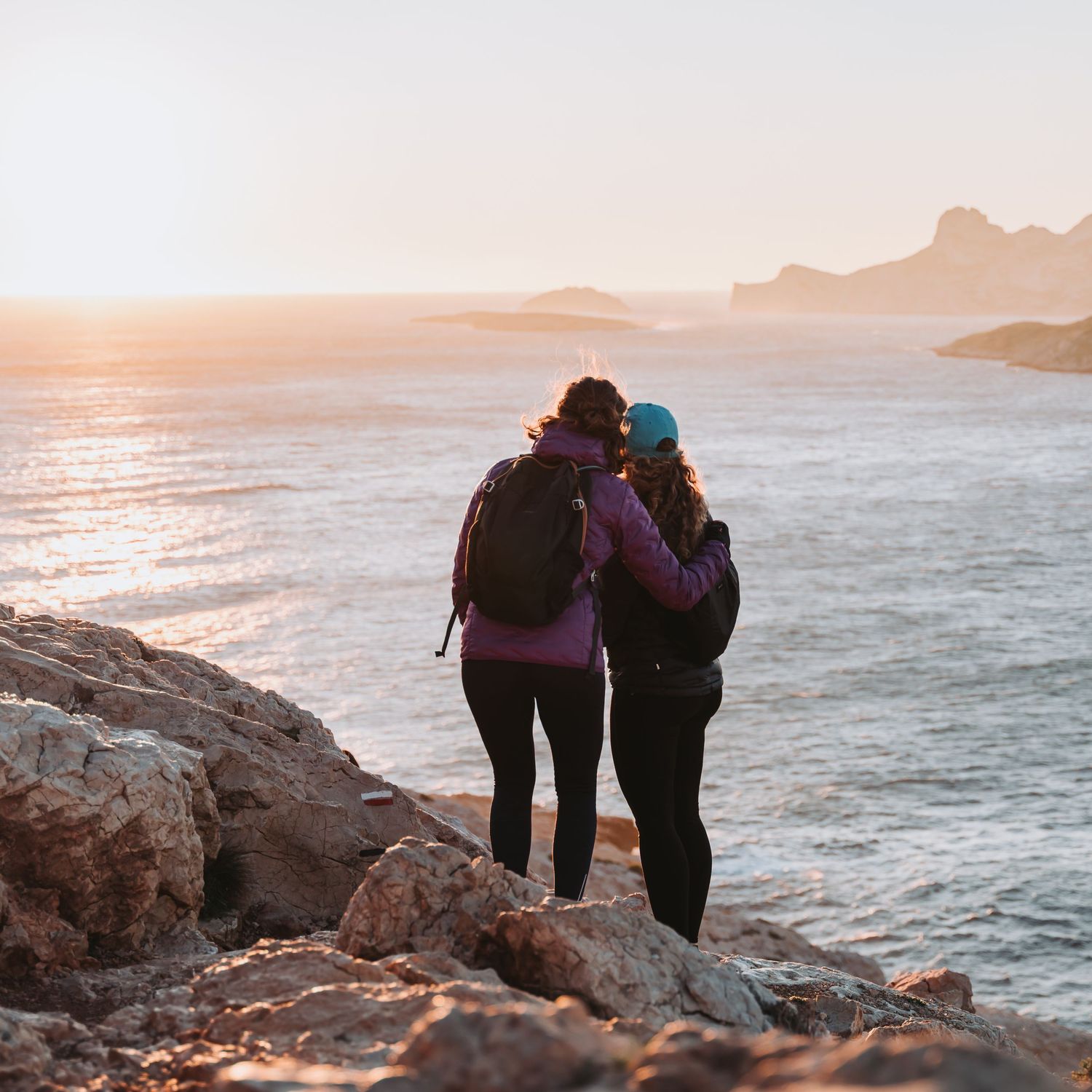 photo de deux femmes qui regarde la mer au soleil levant