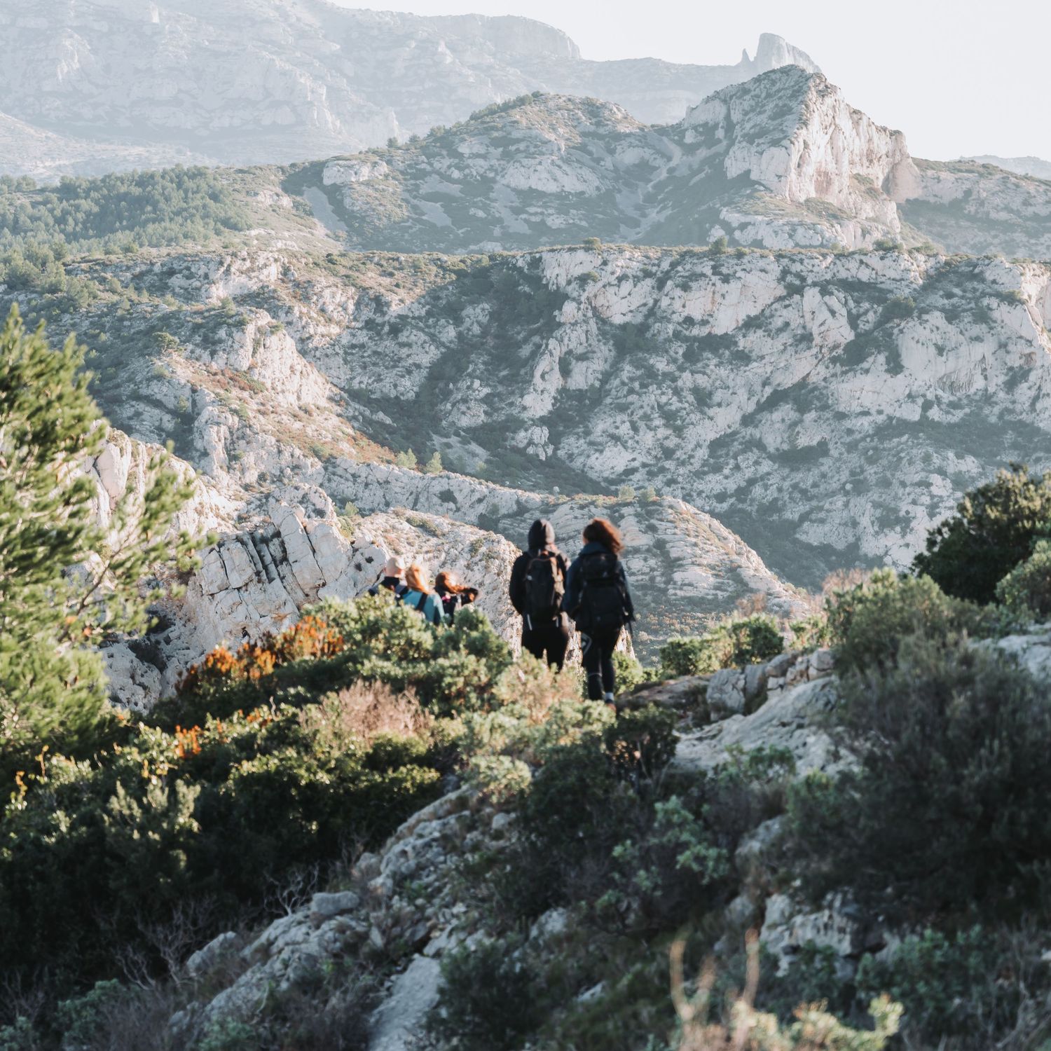 Photo de deux personnes qui marche sur un chemin de randonnée dans la parc national des calanques