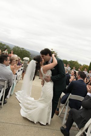 Newlyweds share their first dance at an outdoor wedding reception with guests watching from their seats.
