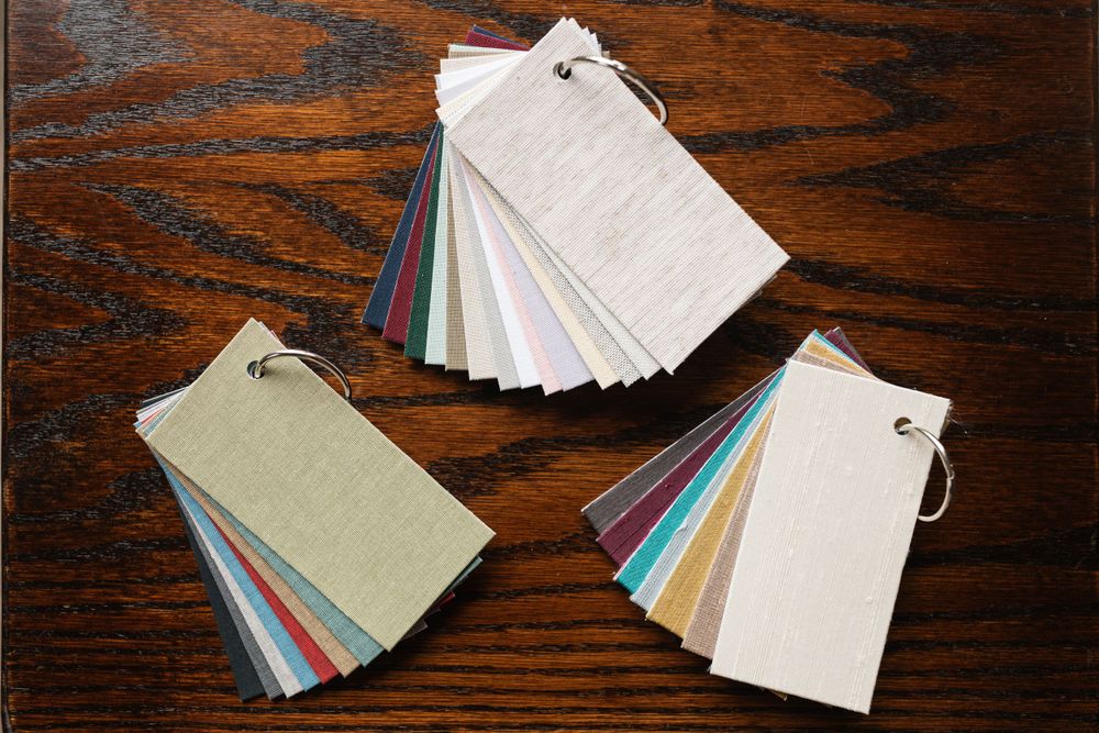 Three sets of color swatches fanned out on a dark wooden surface.