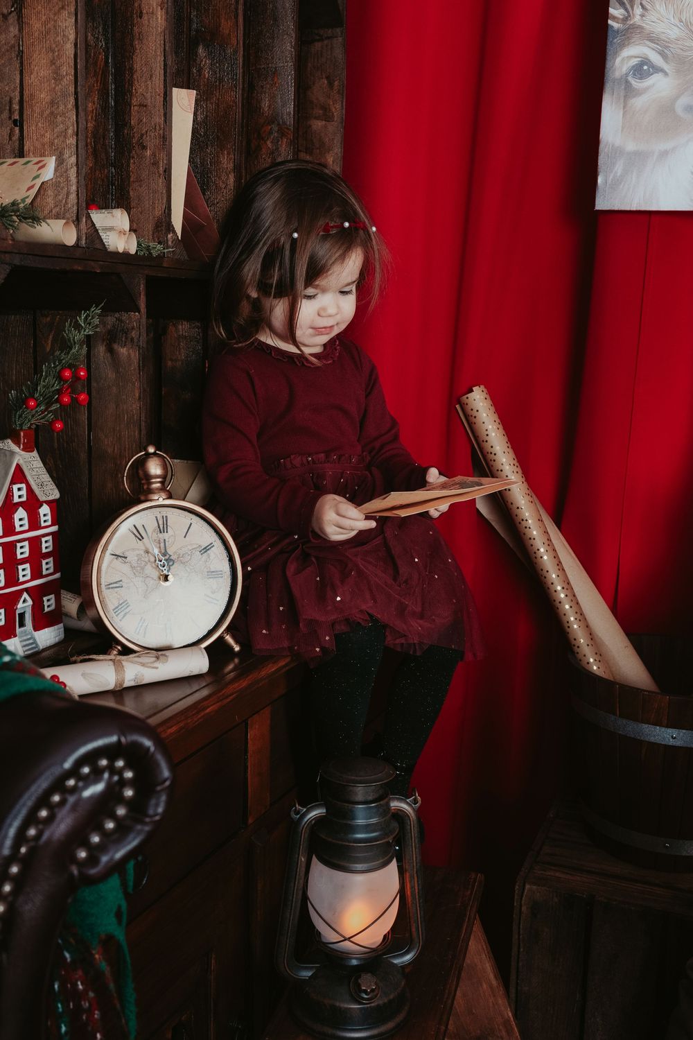 A series of moody photos showing someone examining vintage items against a red curtain backdrop in dim lighting.