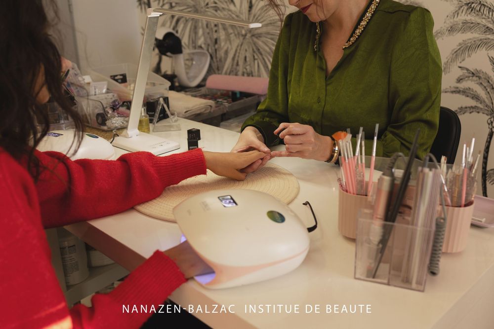Students practice beauty techniques at a training institute while working at individual white stations in a modern classroom setting.