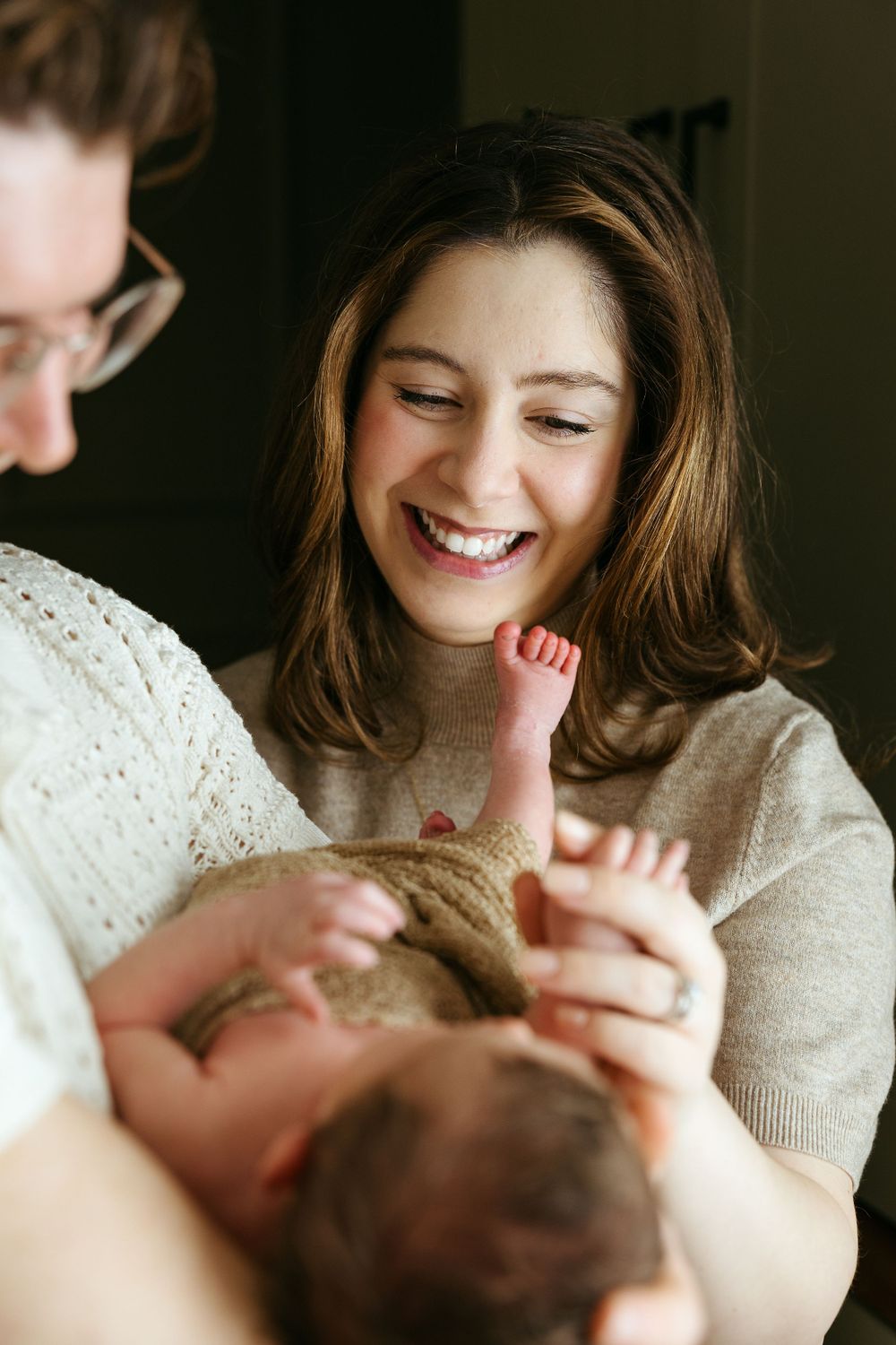 A family shares a joyful moment together as they play and laugh in warm, natural lighting.