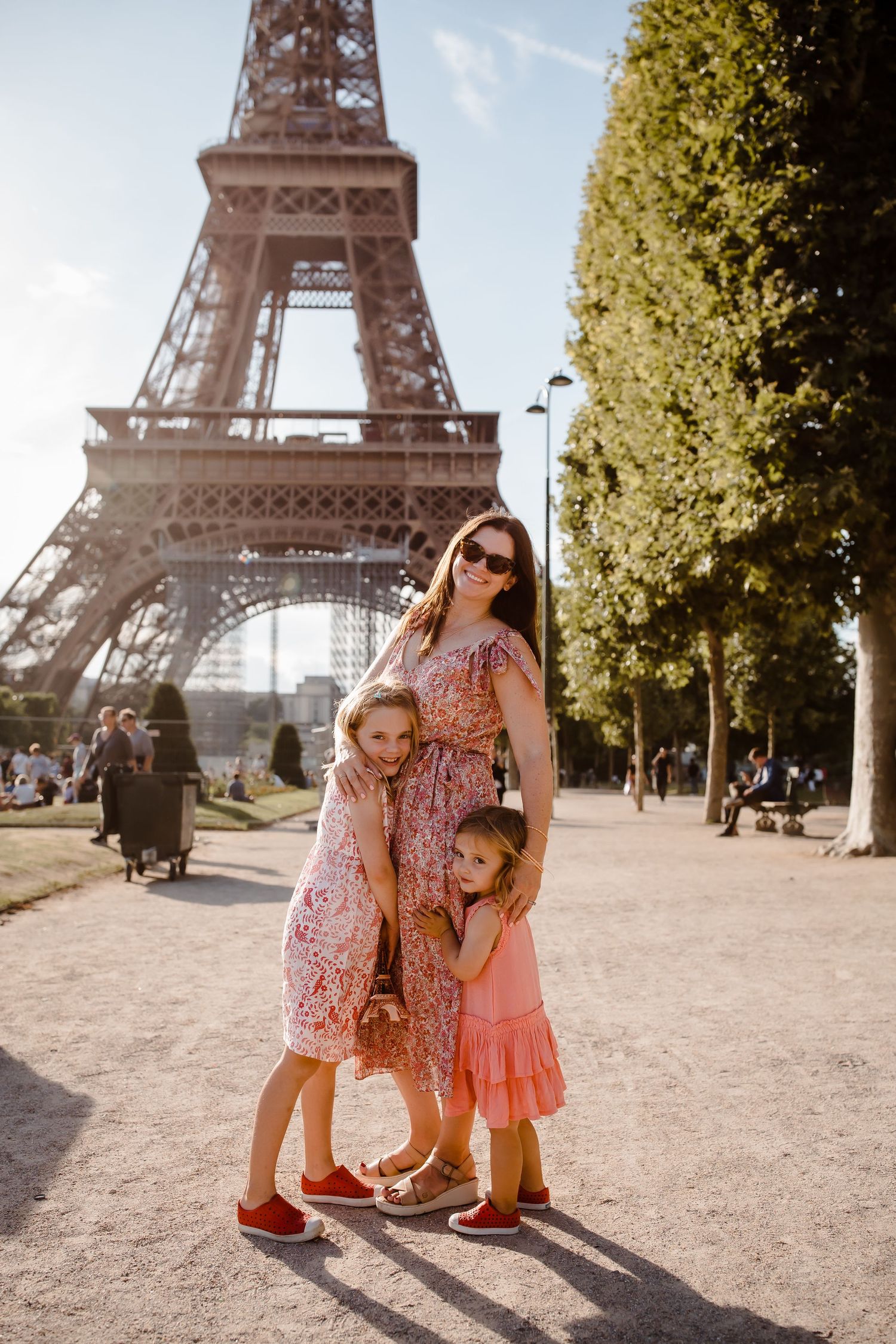 Mother and two children smiling in front of the Eiffel tower