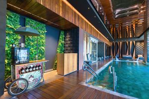Contemporary pool interior at Sofitel Mexico City Reforma with lush green wall, wooden floors and swimming pool.
