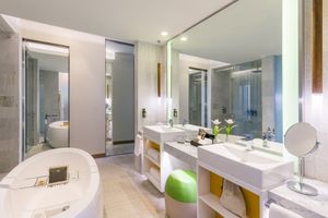 Modern hotel bathroom featuring a long double vanity with mirrors and sleek white fixtures. Sofitel Mexico City Reforma.