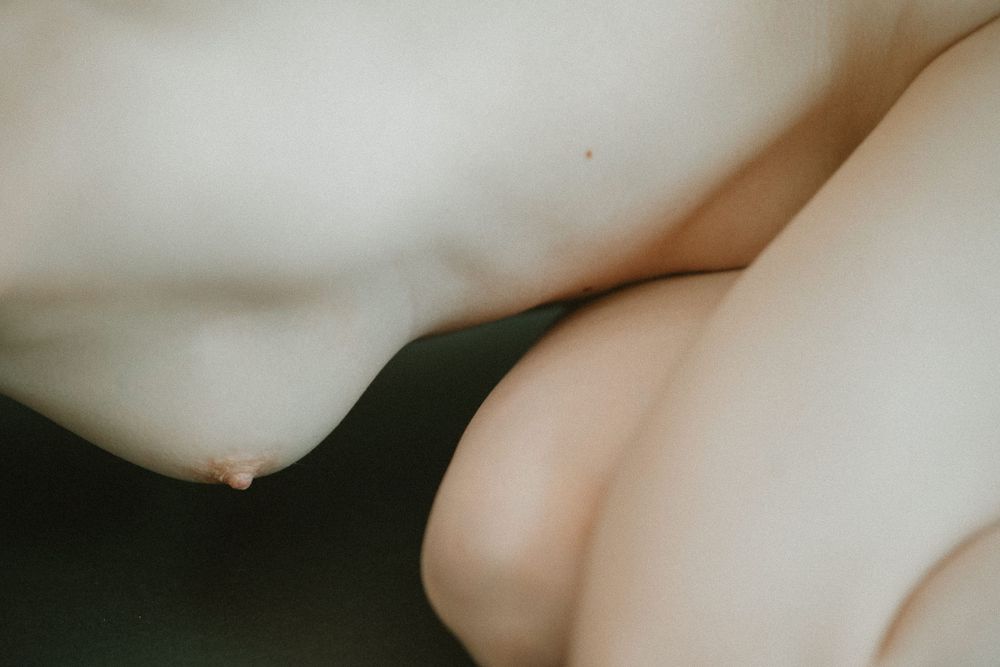 Abstract close-up photograph showing curves and shadows against dark background in muted tones.