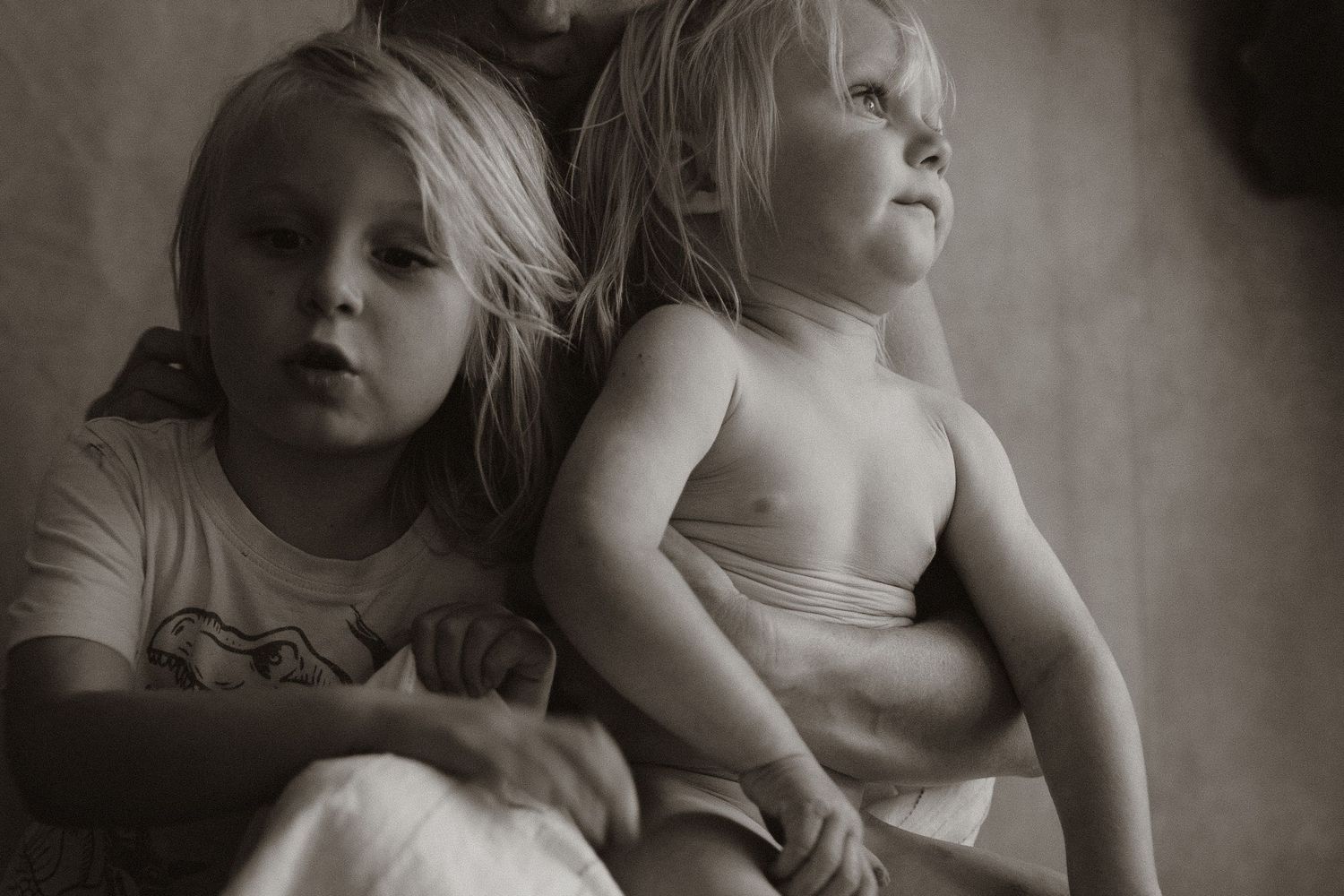 Siblings being cuddled by Mum