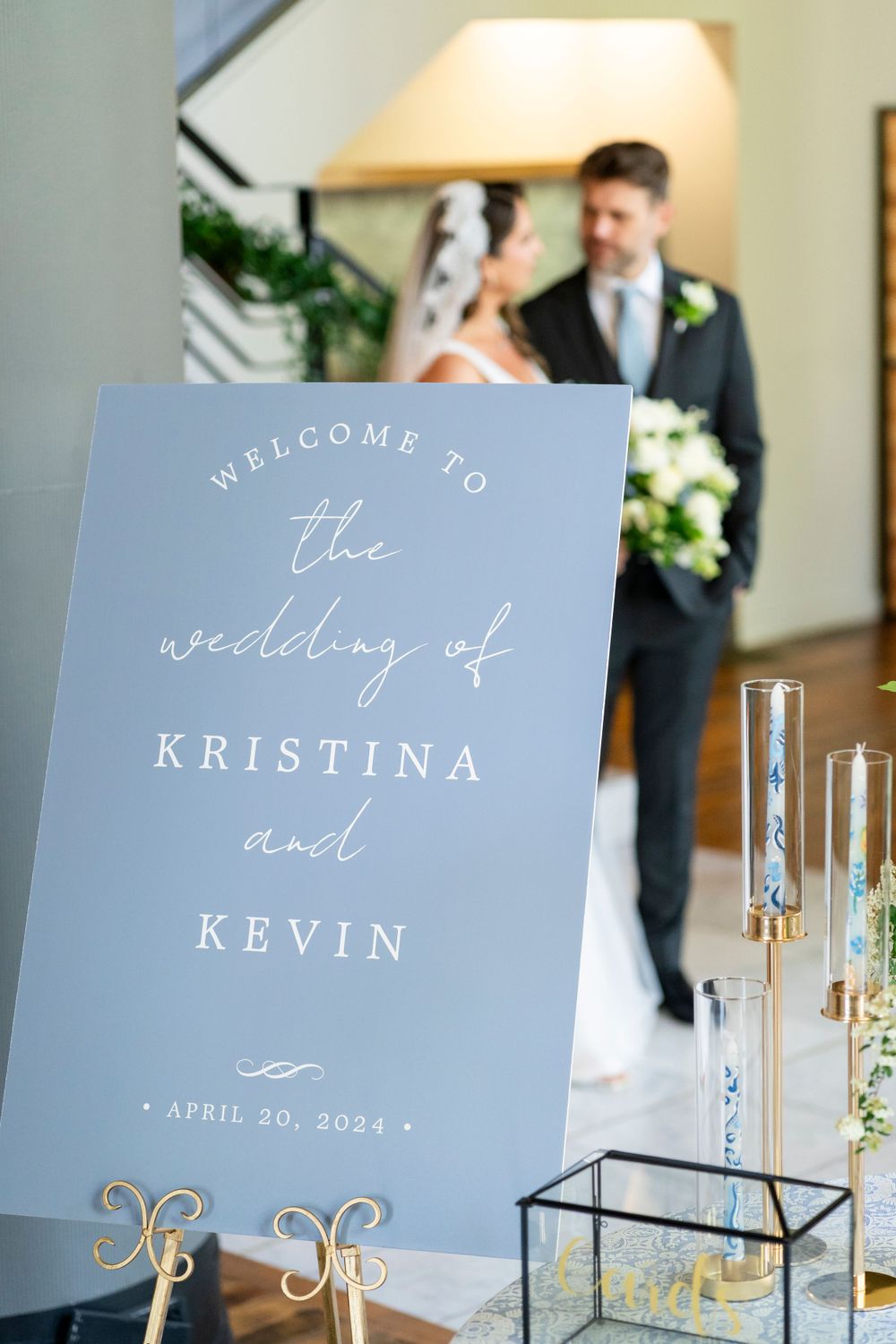Wedding welcome sign for Kristina and Kevin on April 20, 2024, with couple in background.