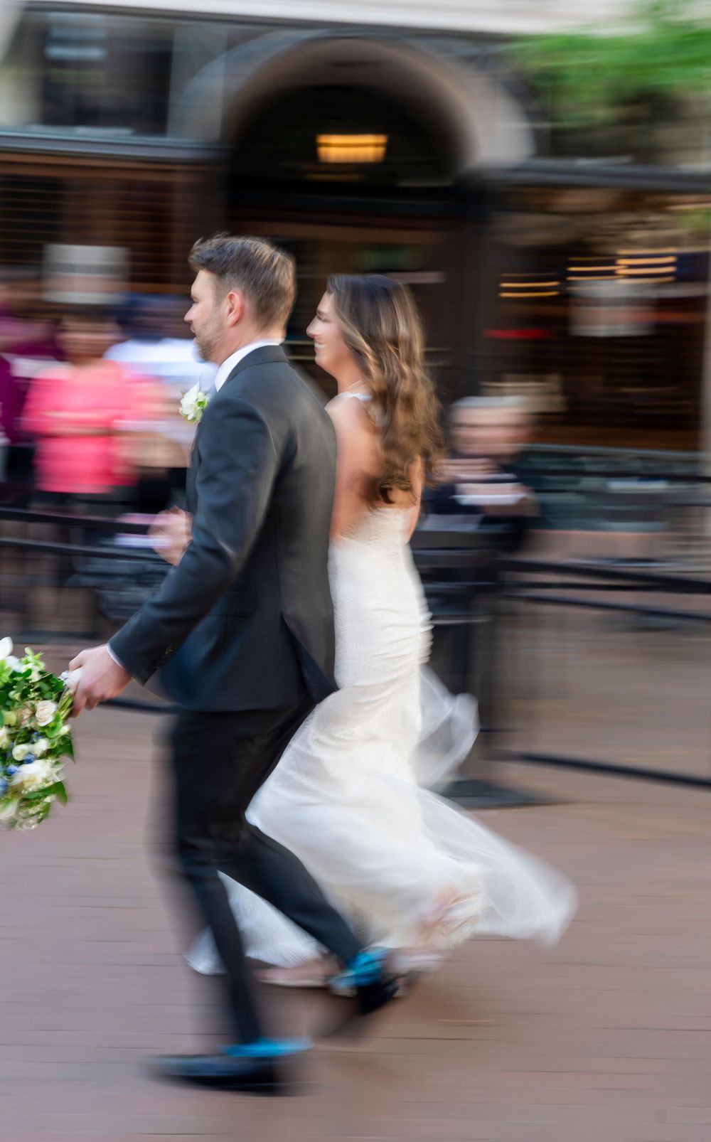 Motion blur photo of bride and groom walking together after their wedding ceremony.