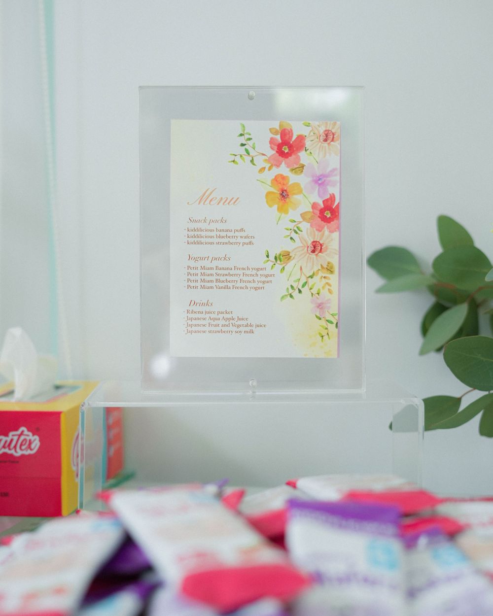 Floral menu card with watercolor design displayed at an event.