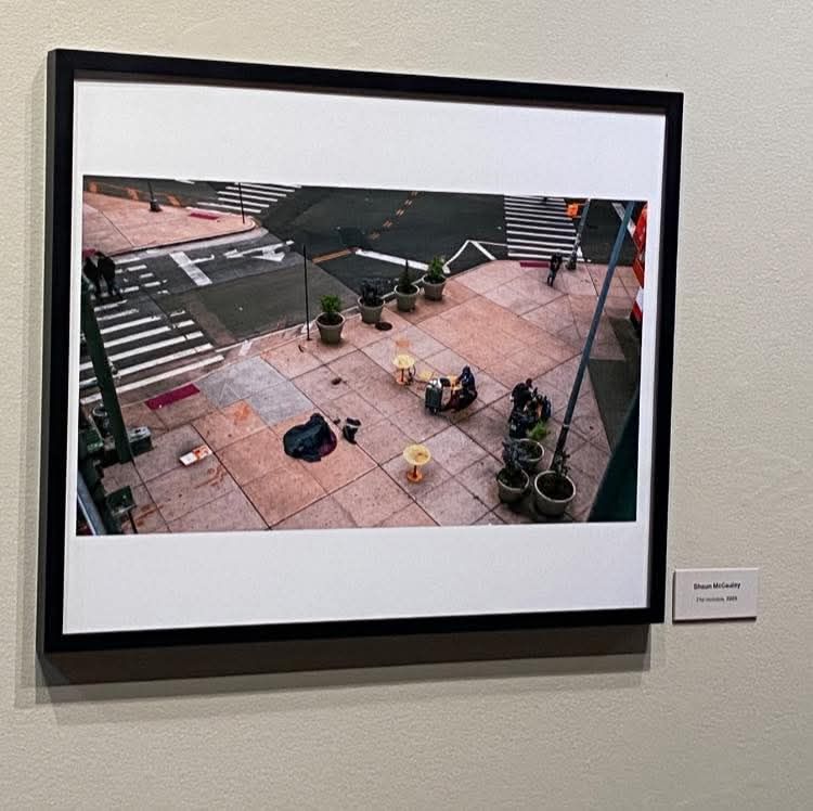 Aerial view of people sitting on an outdoor patio with planters and geometric patterns.