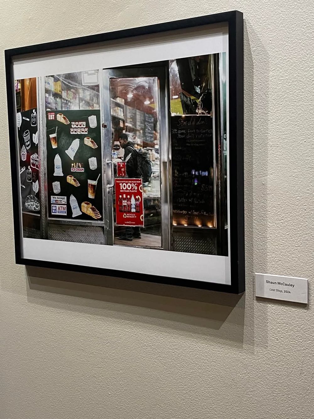 Framed urban photography showing storefronts and street scenes in black and white.