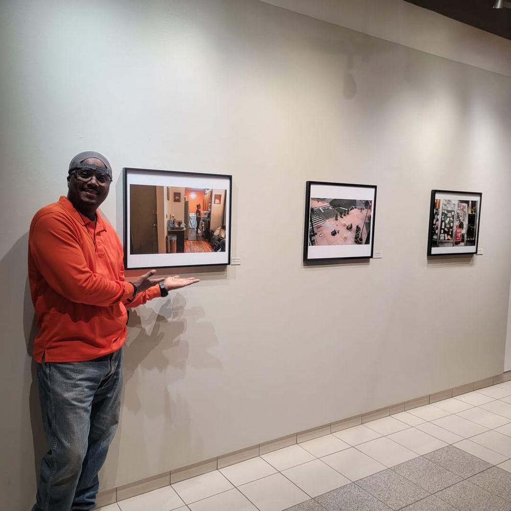 Gallery space with mounted photographs displayed on a clean white wall.