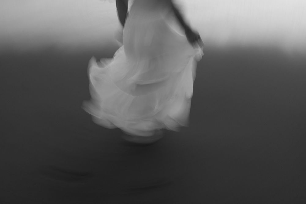 blurred woman in white dress walking on Maui