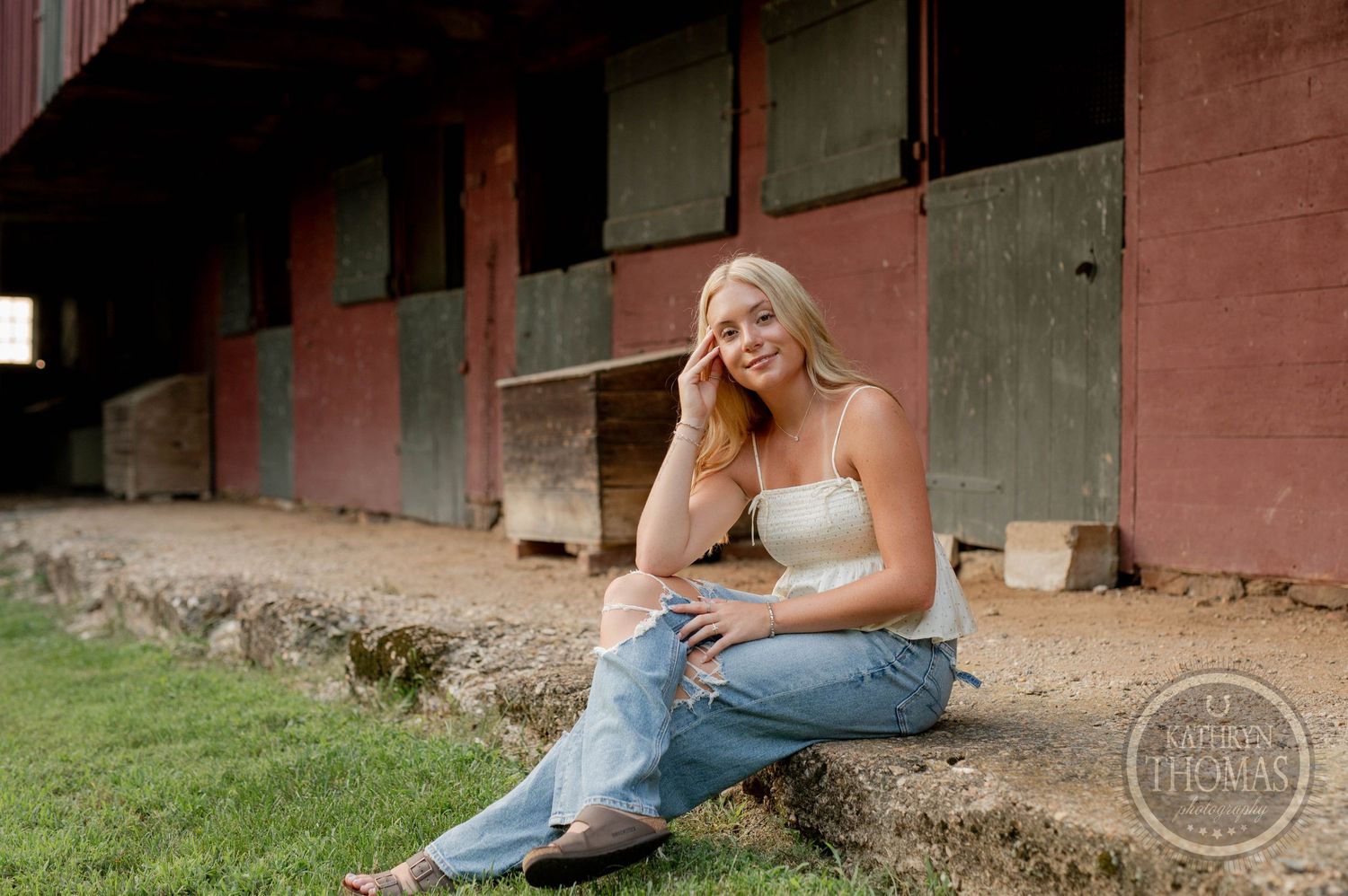 Relaxed countryside photoshoot near vintage barn structure.