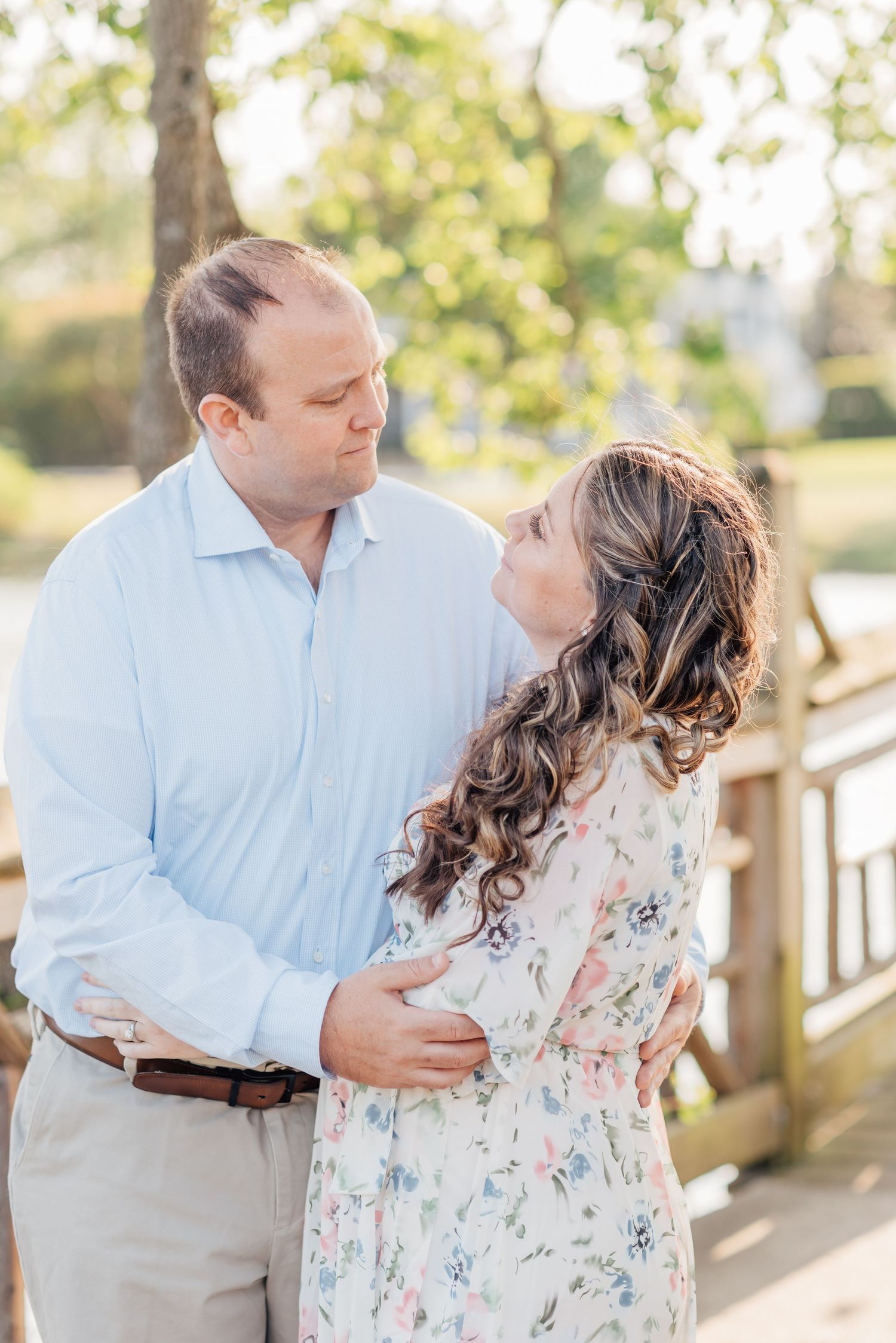A close up from hips up of a couple with a floral dress and blue collar shirt with tan pants.