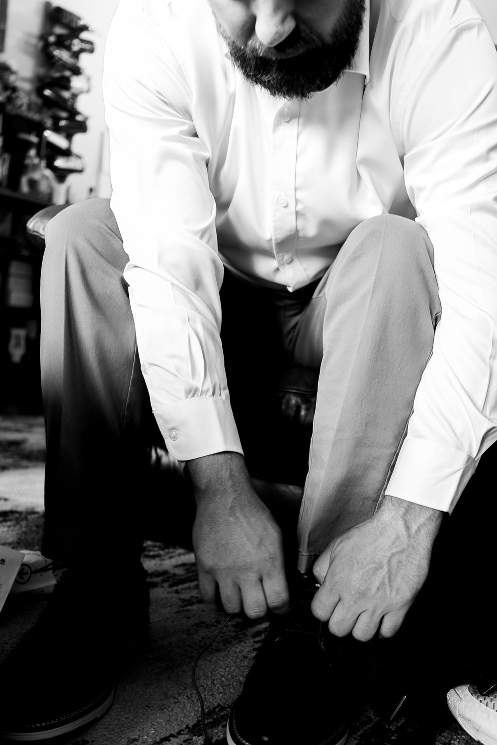 Groom tying his shoes while getting ready for his Missoula wedding.