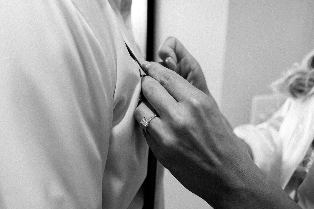 Close-up of bride’s hands showing her engagement ring during wedding morning prep.