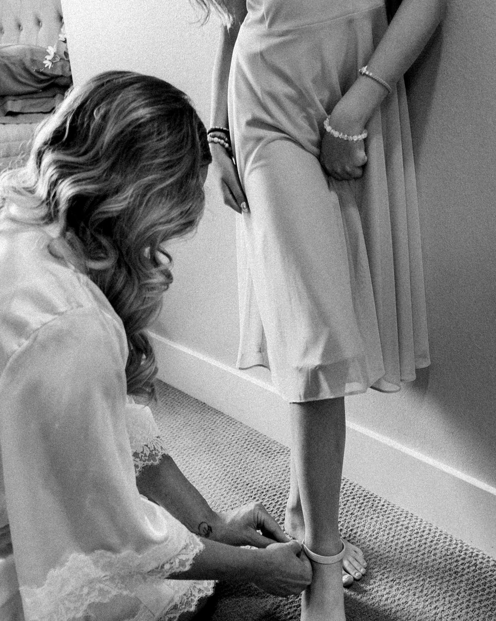 Bride helping daughter get ready for wedding
