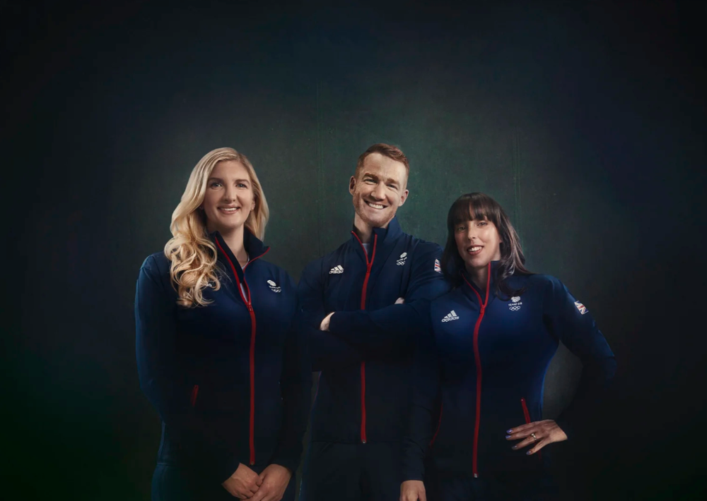 Group photo of athletes in matching team uniforms against dark backdrop.