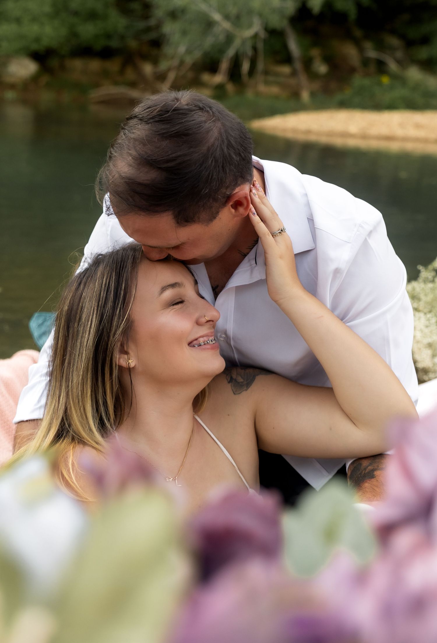 Intimate couple's portrait with soft focus and floral elements in foreground.