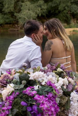 Beautiful floral arrangement of purple and white blooms decorates romantic boat scene.